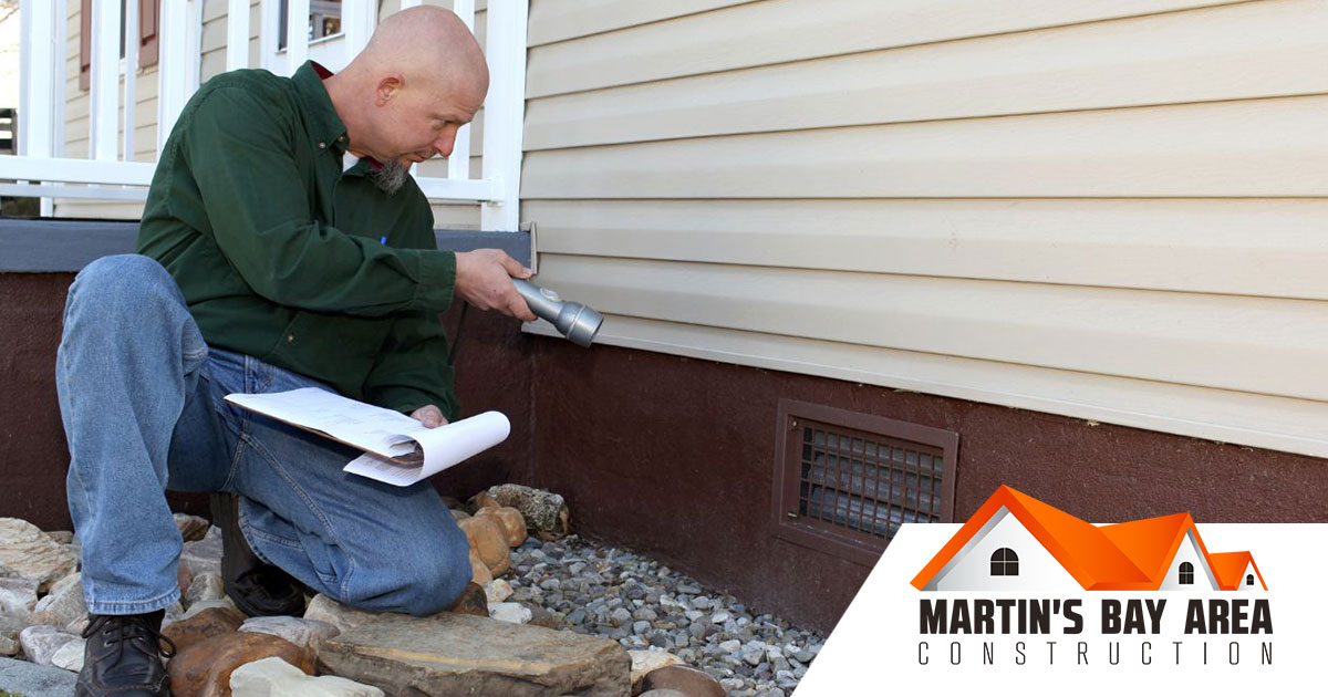 Professional foundation contractor inspecting a home’s foundation for repair.